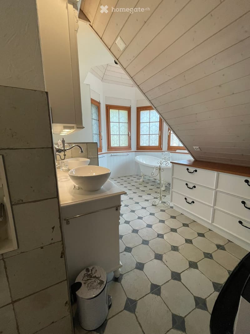 Bathroom with hexagonal tile floor, white sink, bathtub, and wooden cabinet.