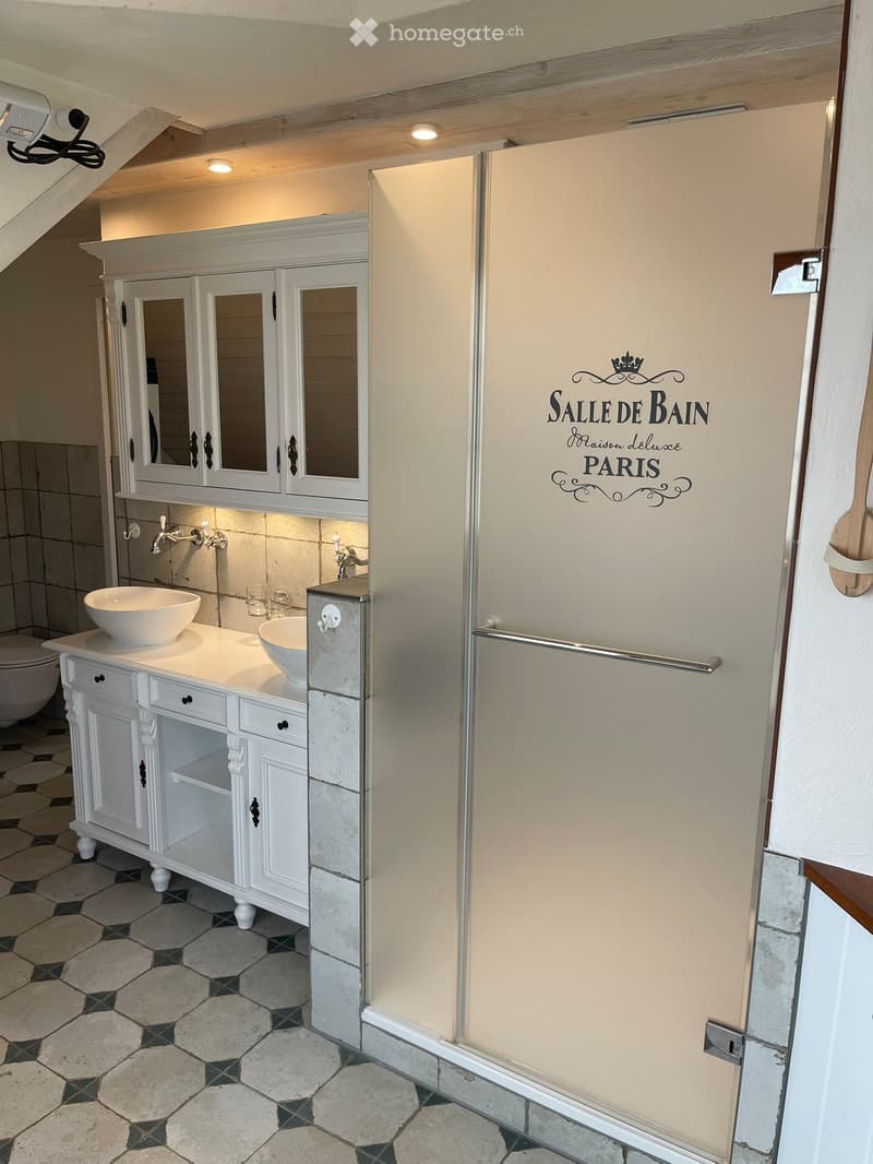 Elegant bathroom with white cabinetry, double sinks, mirrors, and a decorative sign reading "SALLE DE BAIN Maison deluxe PARIS".