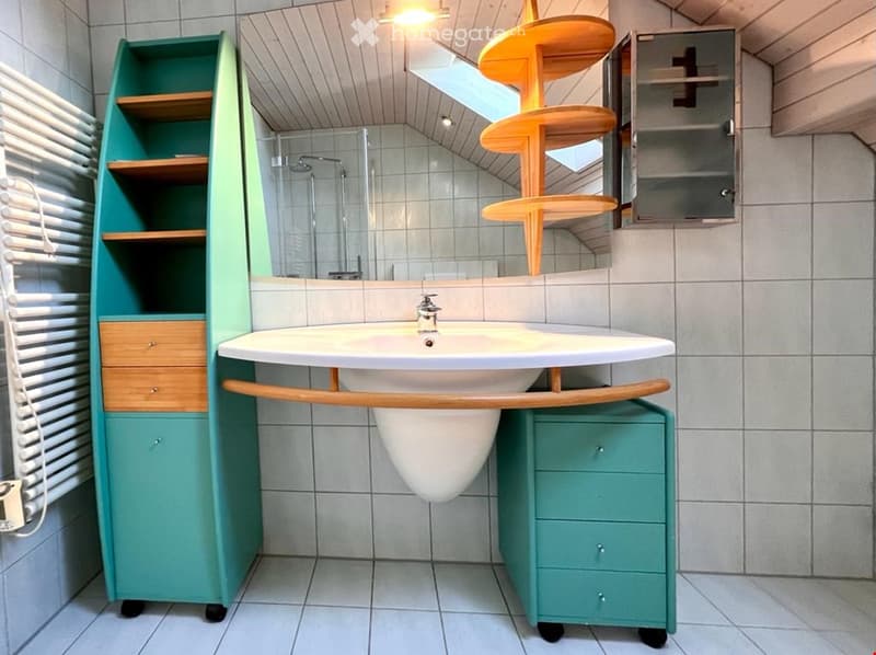 modern bathroom with white sink, white bathtub, white wall, green storage cabinets, wooden cabinet, white tiles, light fixture, and mirror