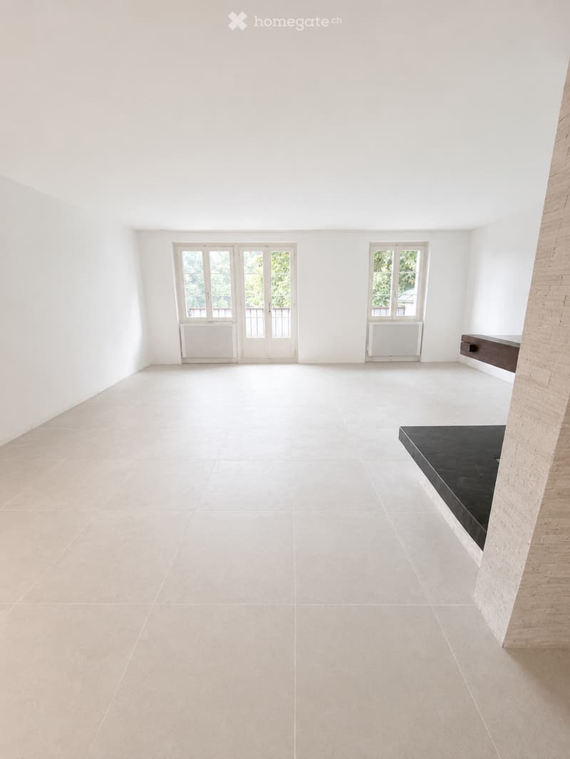 Empty room with white walls, large windows, and tiled floor. No furniture or equipment present.