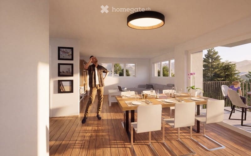 Bright dining area with wooden floor, large windows, dining table with chairs, laptop on table, sofa, and picture frames on wall.