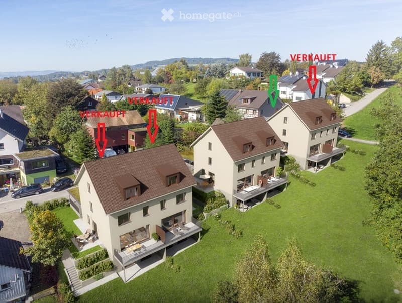 Aerial view of a residential neighborhood with multiple houses, green lawns, and trees. Some houses are marked as sold with red arrows and text.