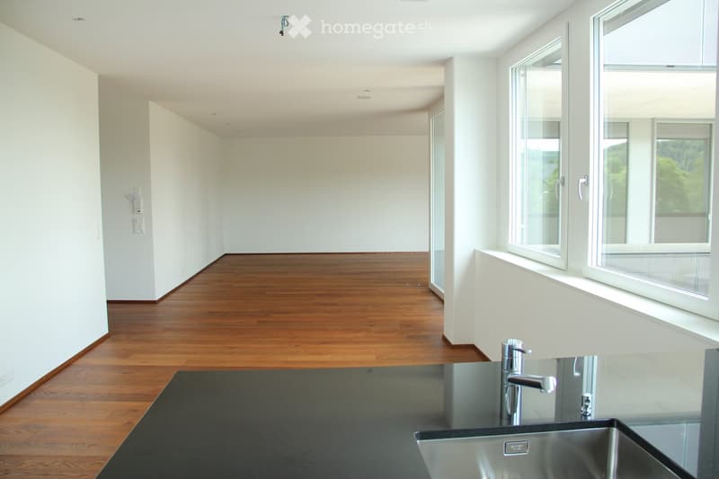 Empty room with white walls, wooden flooring, and large windows allowing natural light. No furniture or equipment present.