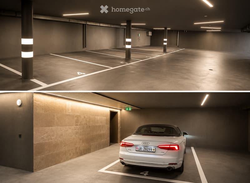 Modern underground parking area with concrete floors and walls, marked parking spaces, and a white Audi convertible parked in one of the spots.