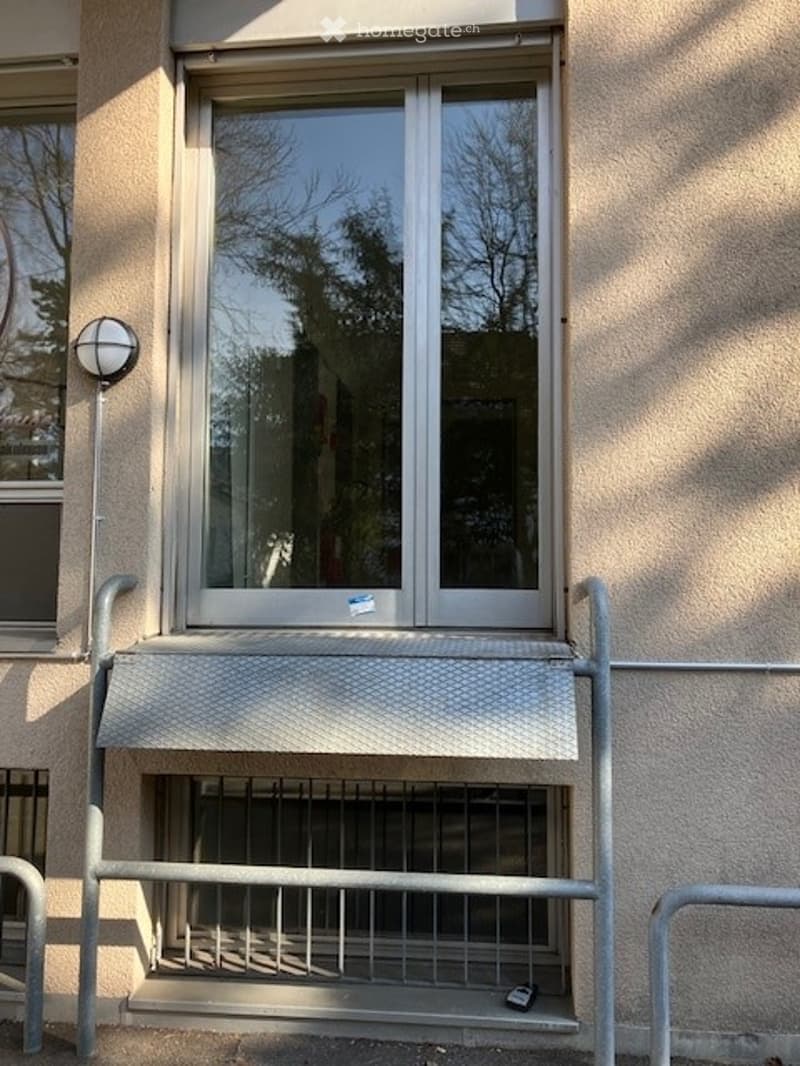 Exterior wall with a window, metal railing, and a lamp