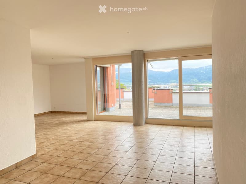 Empty room with tiled floor, large windows, and scenic mountain view.