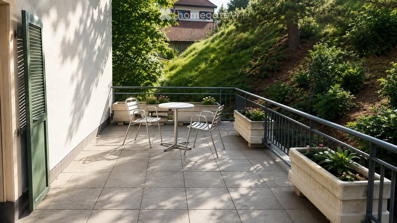 Balcony with tiled floor, metal railing, small round table, four chairs, and several flower boxes.
