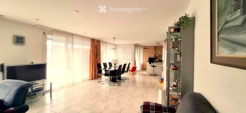 living room with dining area, white tiles, white walls, large windows, curtains, table, chairs, TV, cabinet, shelves, picture frame