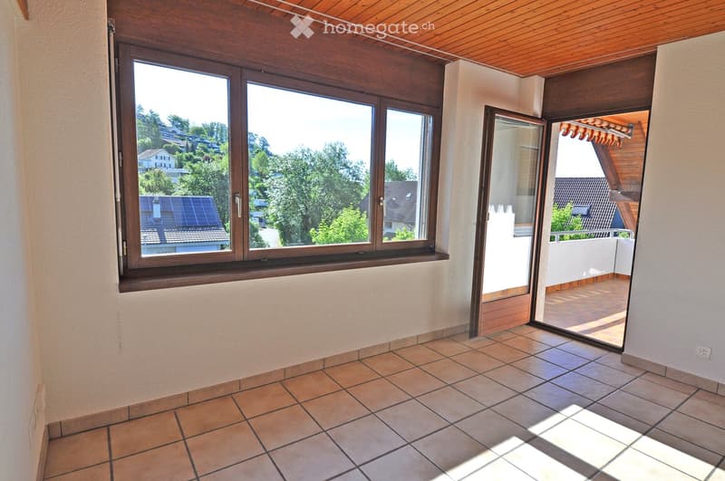 Empty room with tiled floor, large window, and sliding glass door leading to a balcony.
