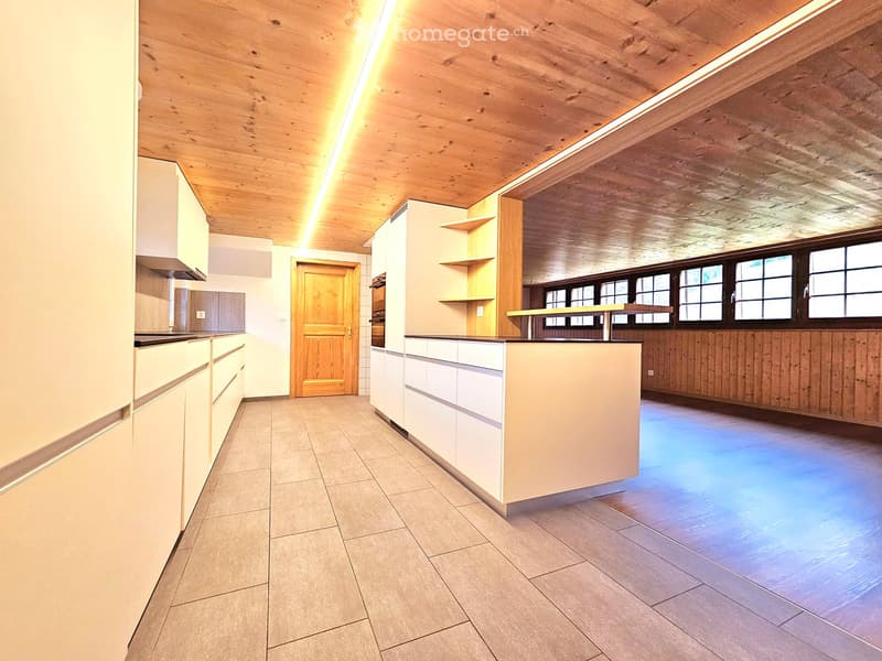 Modern kitchen with white cabinets, a central island, wooden shelves, and large windows, featuring a clean and minimalist design.