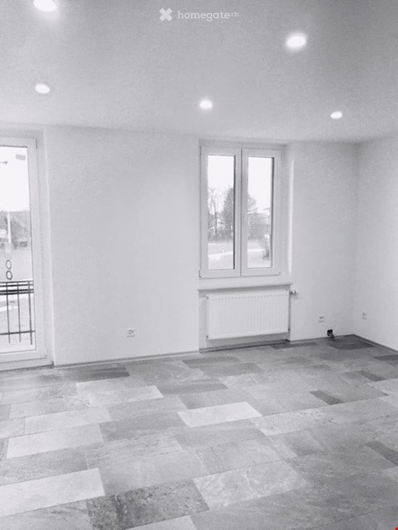 room with white walls and windows, a white tile floor, and a window with a view