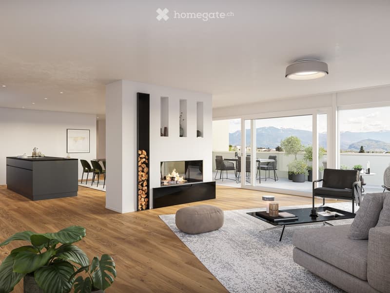 Modern living room with a grey sofa, coffee table, ottoman, and fireplace. Large windows offer a scenic mountain view. Kitchen island and dining area visible.