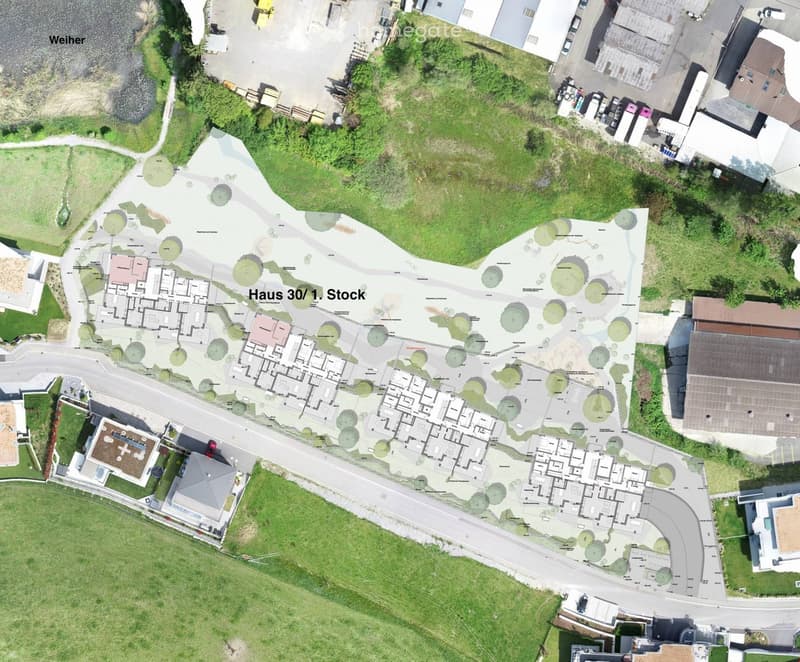 Aerial view of a residential development plan showing multiple house layouts, green spaces, pathways, and surrounding buildings.