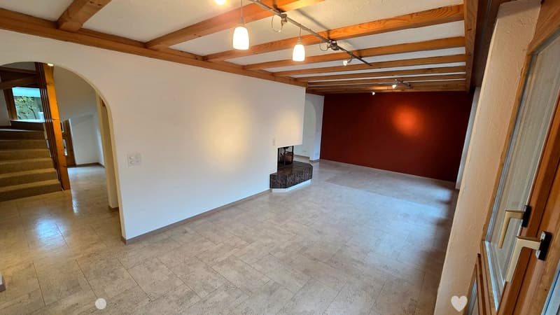 Empty hallway with exposed wooden beams, tiled floor, and a small bench with a mirror against the wall.