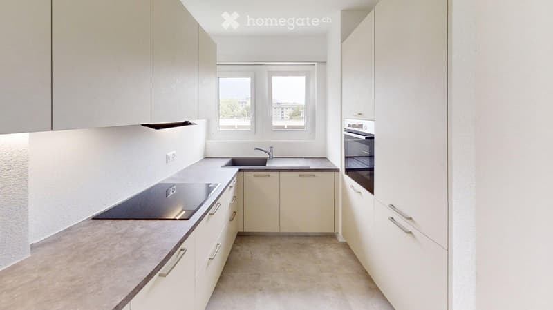 Modern kitchen with white cabinets, a sink, a faucet, an oven, and a countertop.