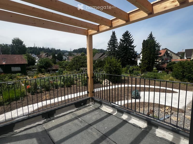 Roof terrace with wooden pergola, metal railing, and view of garden and surrounding houses.