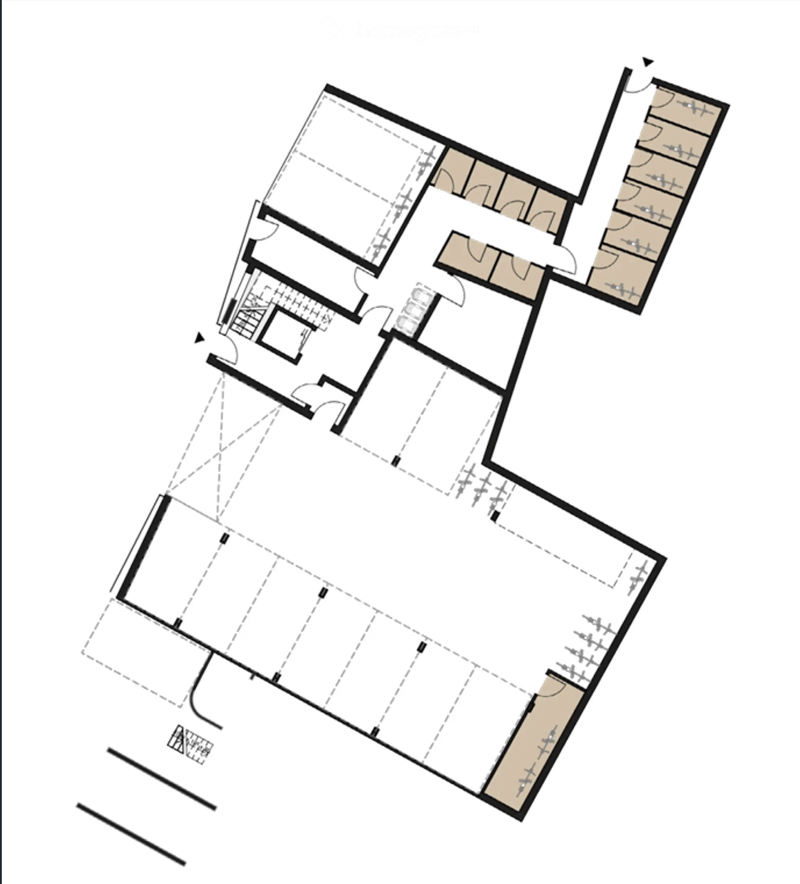 Floor plan of a multi-room building with several rooms, including a large central space, smaller rooms, and a staircase leading to an upper level.