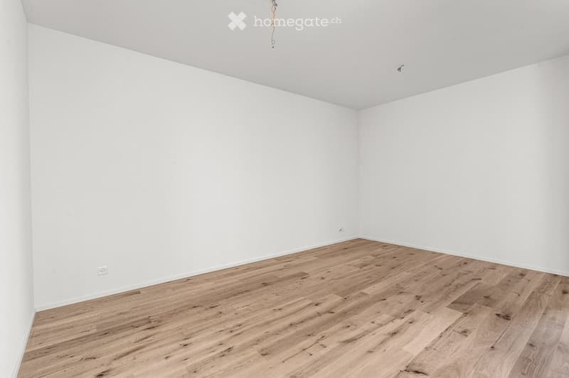 Empty room with white walls and light wooden flooring, no furniture or equipment present.