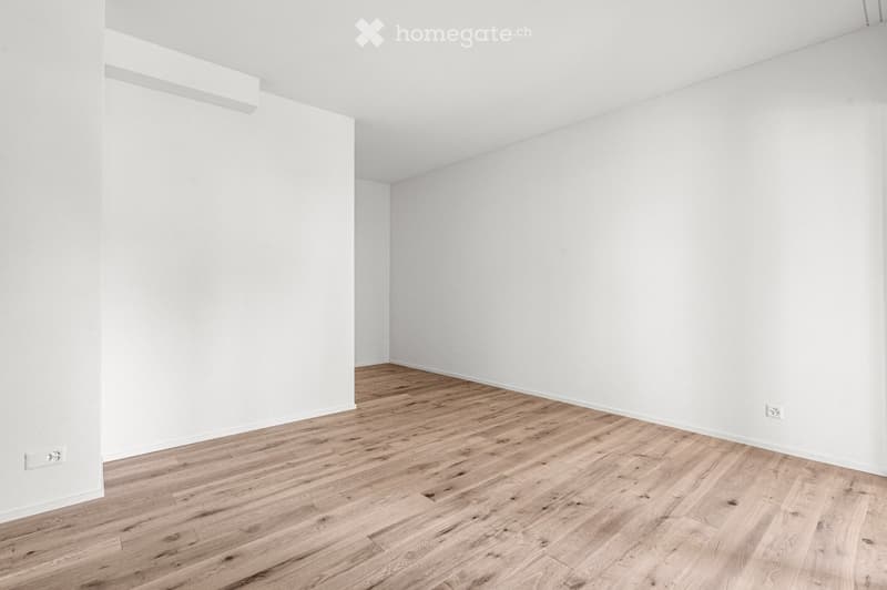 Empty room with white walls and light wooden flooring, no furniture or equipment.