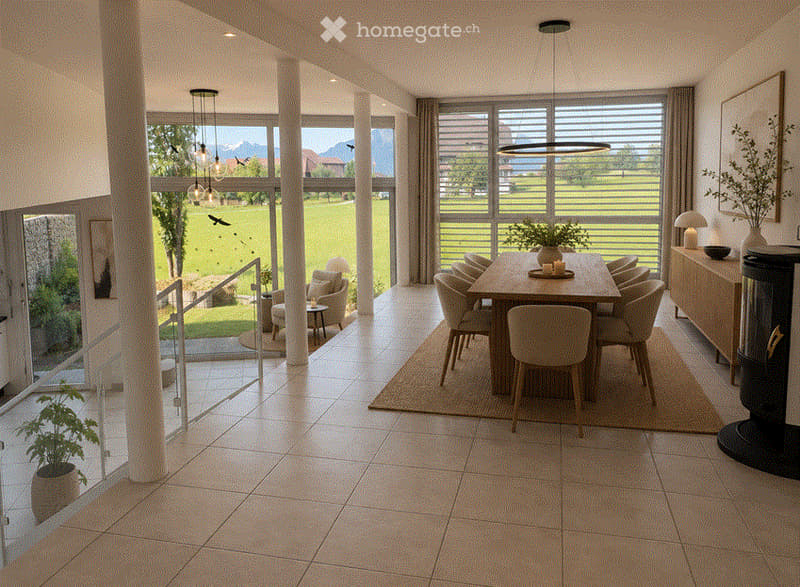Bright dining area with large windows offering a scenic view, featuring a wooden dining table surrounded by chairs, a sideboard, a fireplace, and potted plants.