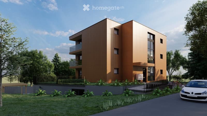 Modern multi-story building with wooden facade, large windows, and balconies, surrounded by greenery and a paved driveway.