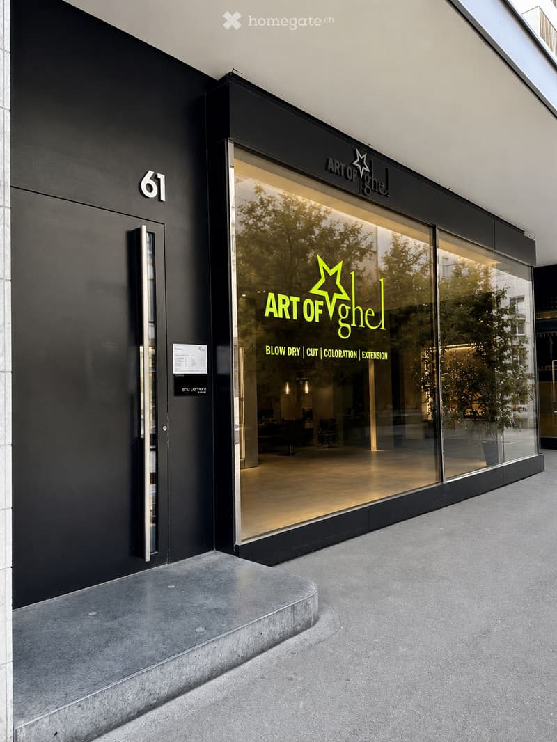 Modern storefront with large glass windows and black facade, displaying signage for 'ART OF VGHEL' and services like blow dry, cut, coloration, and extension.