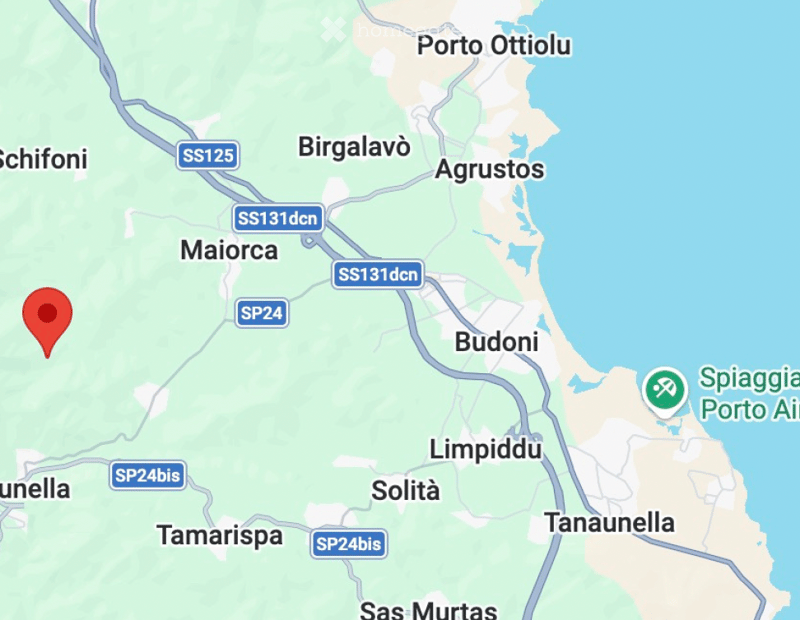 Map showing a location marked with a red pin in an area surrounded by roads and nearby towns.