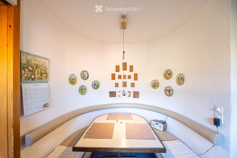 Dining area with a round table, wall decorations, and a calendar