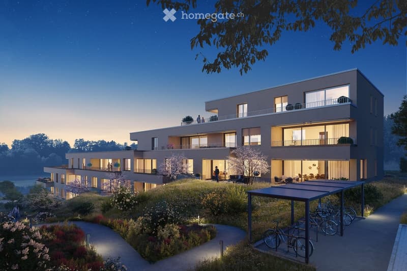 Modern two-story residential building with balconies, large windows, and a landscaped garden area with bicycles and a covered parking area.