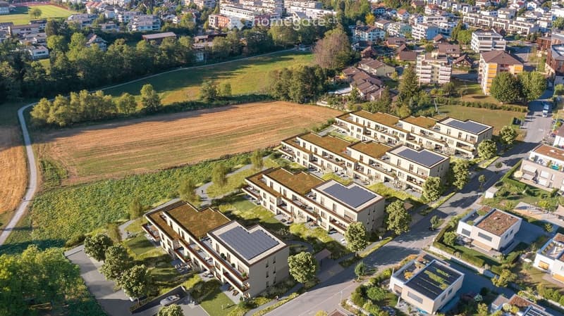 Aerial view of a residential area with multiple modern apartment buildings, green spaces, and surrounding neighborhood.