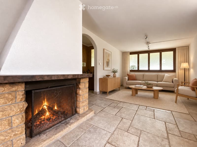 Living room with a stone fireplace, beige sofa, coffee table, armchair, side table, and floor lamp.