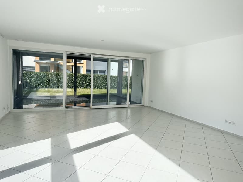 Empty room with glass sliding doors, tile flooring, white walls