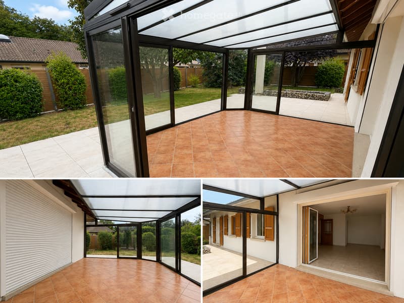 A modern glass-enclosed patio with terracotta tiles, large sliding glass doors, and a view of a well-maintained garden with greenery and a stone pathway.