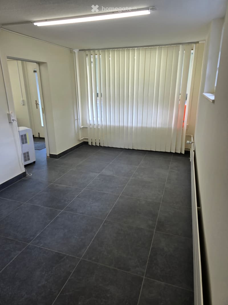 Empty hallway with dark tiled floor, white walls, and vertical blinds covering a window. An air conditioning unit is visible on the left side.