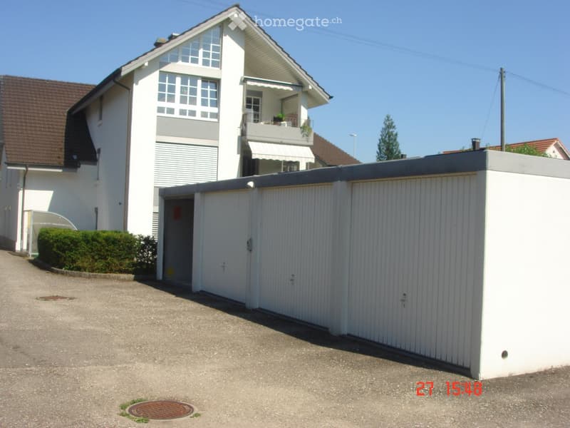 Two-story house with white exterior, brown roof, garage, and balcony on the upper level.