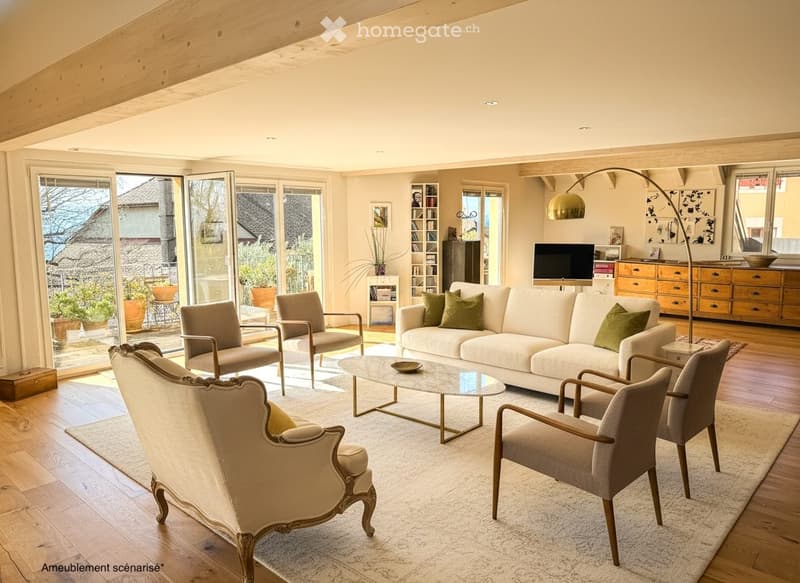 Modern living room with large windows, white sofa, coffee table, armchairs, TV, floor lamp, and bookshelf.