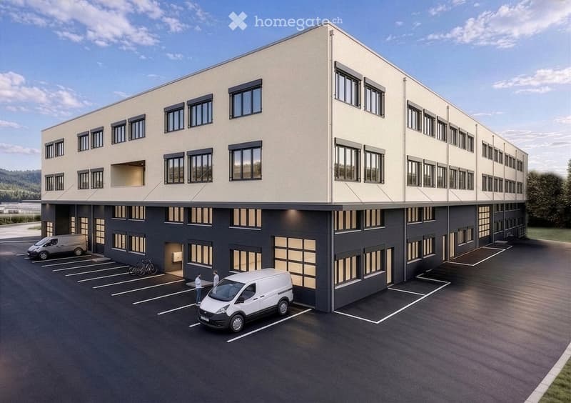 Modern two-story building with light beige upper facade and dark gray lower level, multiple windows, and a spacious parking lot with several vans and bicycles.
