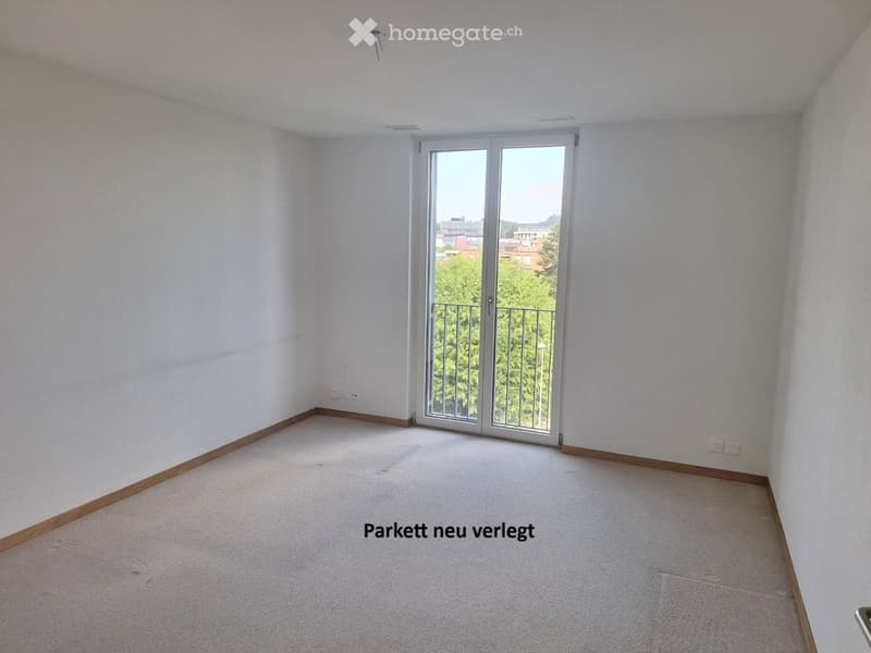 Empty room with white walls, carpeted floor, and large sliding glass door leading to a balcony.