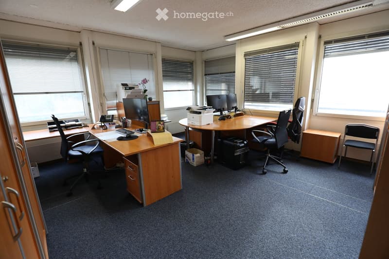 Office with two desks, chairs, computers, printer, and storage boxes.