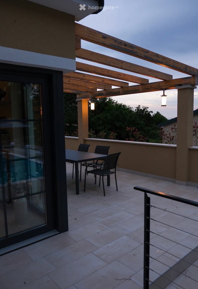 Balcony with a wooden pergola, tiled floor, and a small dining set including a table and chairs.