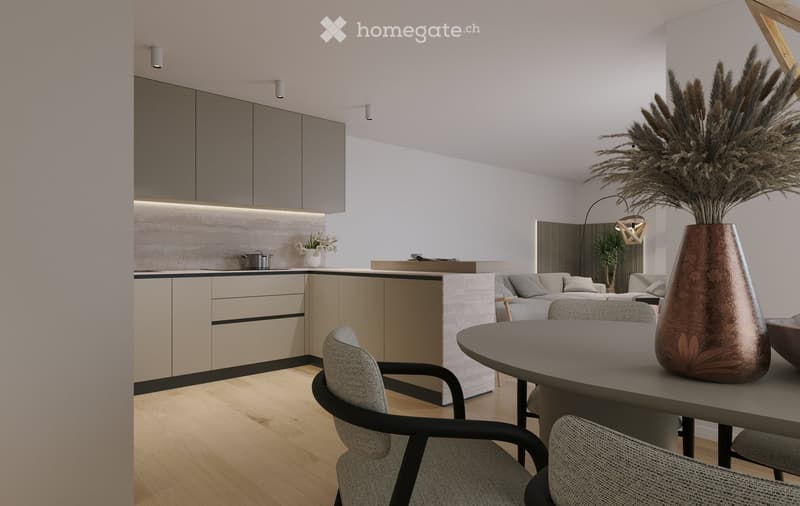 Modern open-plan living and dining area with a grey sofa, round dining table, chairs, and a tall vase with dried plants. The kitchen features sleek cabinets, a central island, and built-in lighting.