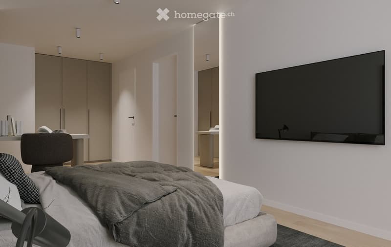 Modern bedroom with a large bed, a wall-mounted screen, a chair, a small table with books, and a wardrobe in the background.
