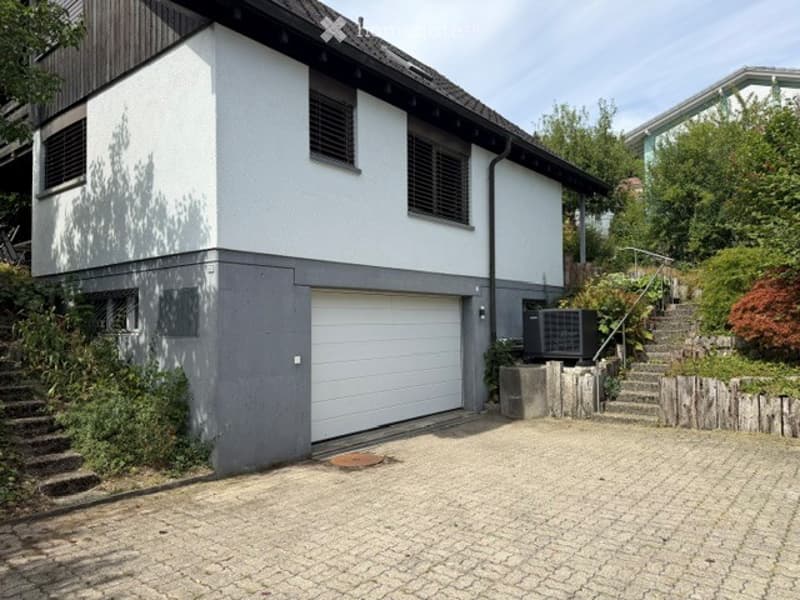 Two-story house with white and grey exterior, garage, and driveway.
