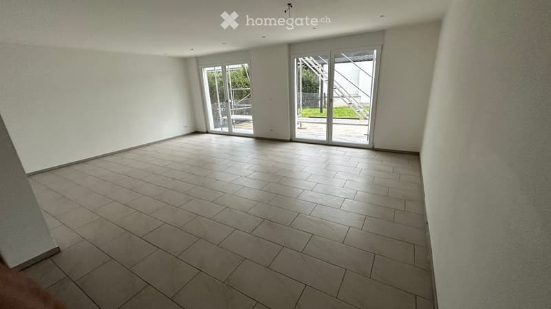 Empty room with tiled floor and large sliding glass doors leading to an outdoor area.