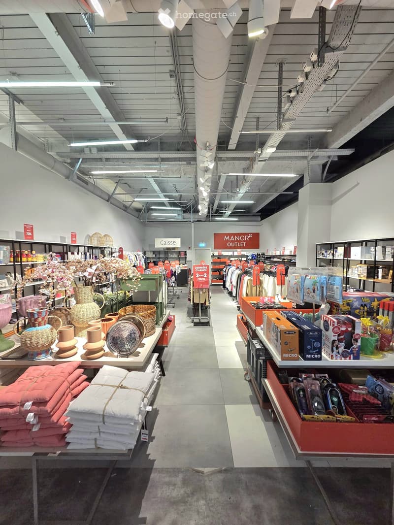 Interior of a retail store with various products displayed on shelves and tables, including home decor, clothing, and toys.