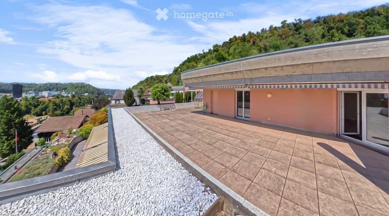 Roof terrace with tiled flooring, modern building facade, scenic view of greenery and cityscape.