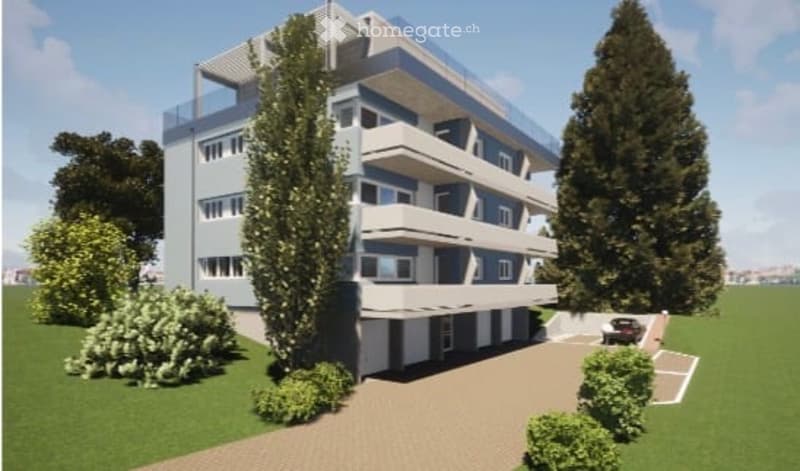 Modern multi-story apartment building with balconies, surrounded by greenery and a paved parking area.