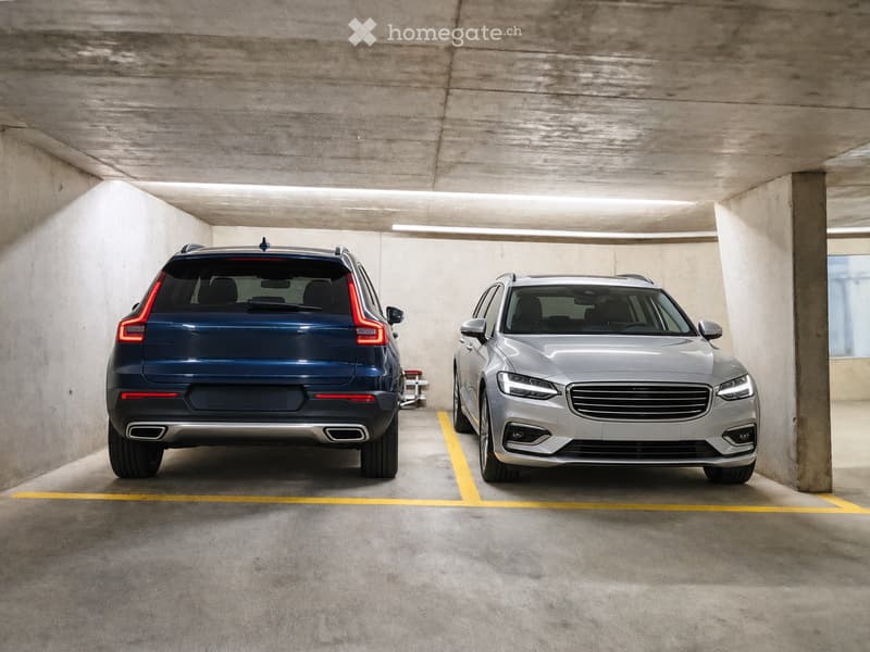{"type": "Garage", "objects": [], "description": "Underground parking area with two parked cars, one blue and one silver, marked parking spaces, and concrete walls and ceiling.", "localized_descriptions": {"EN": "Underground parking area with two parked c