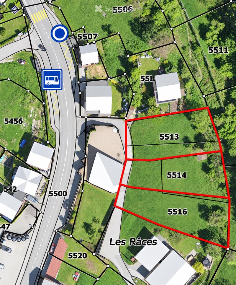 Aerial view of a residential area showing multiple plots and buildings, with numbered zones and road markings.