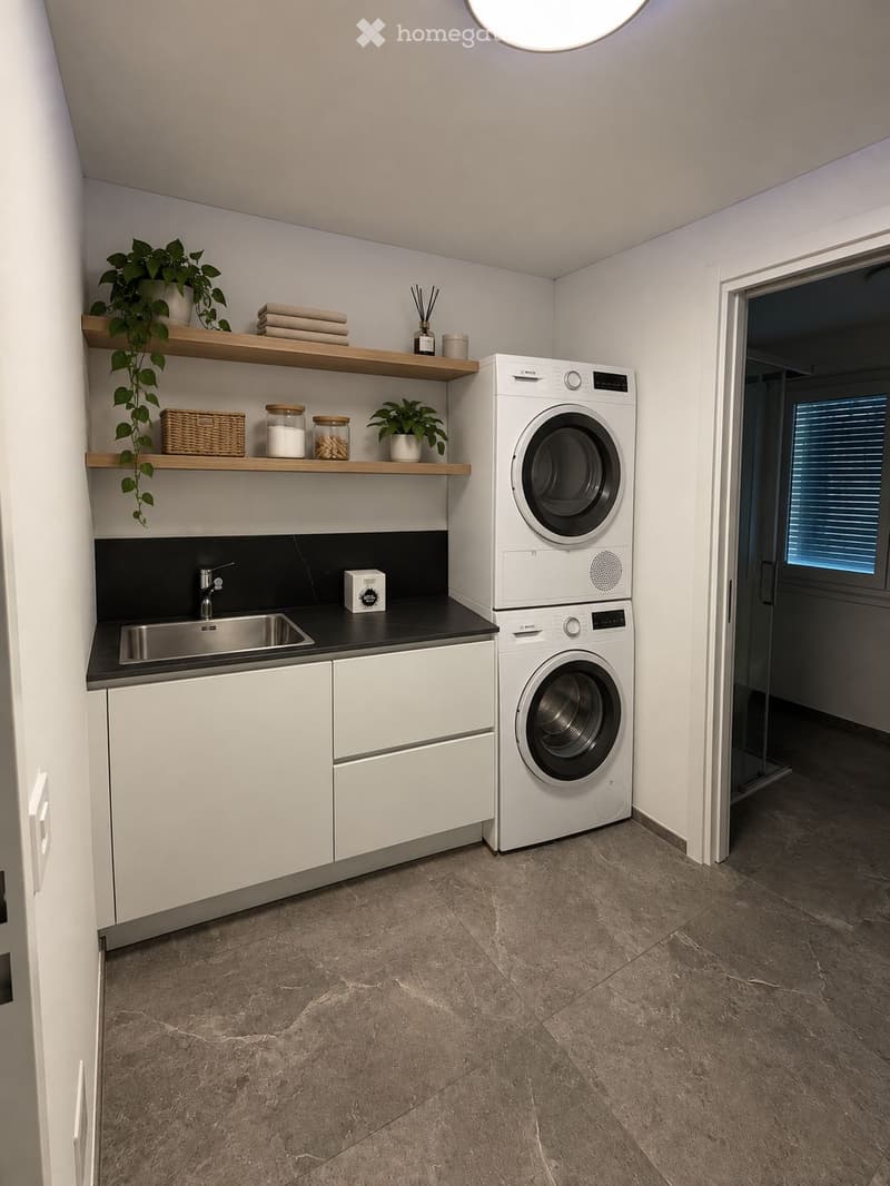 Modern laundry room with white cabinets, a stainless steel sink, a stacked washer/dryer, wooden shelves holding plants and towels, and a small basket.